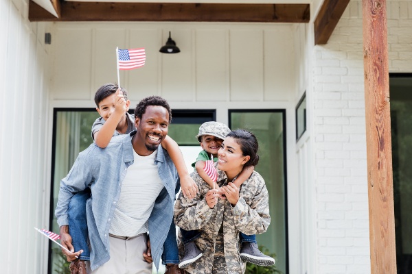 Happy military family in front of home